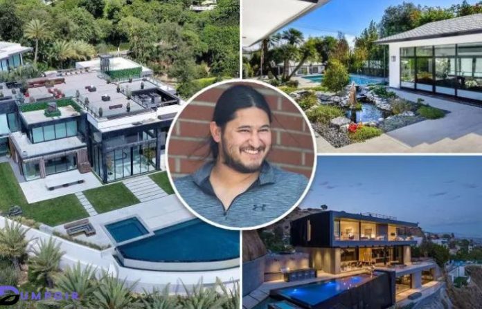 Edwin Castro with a proud smile in front of opulent Los Angeles mansion, signifying his ownership of the priciest home in the area.